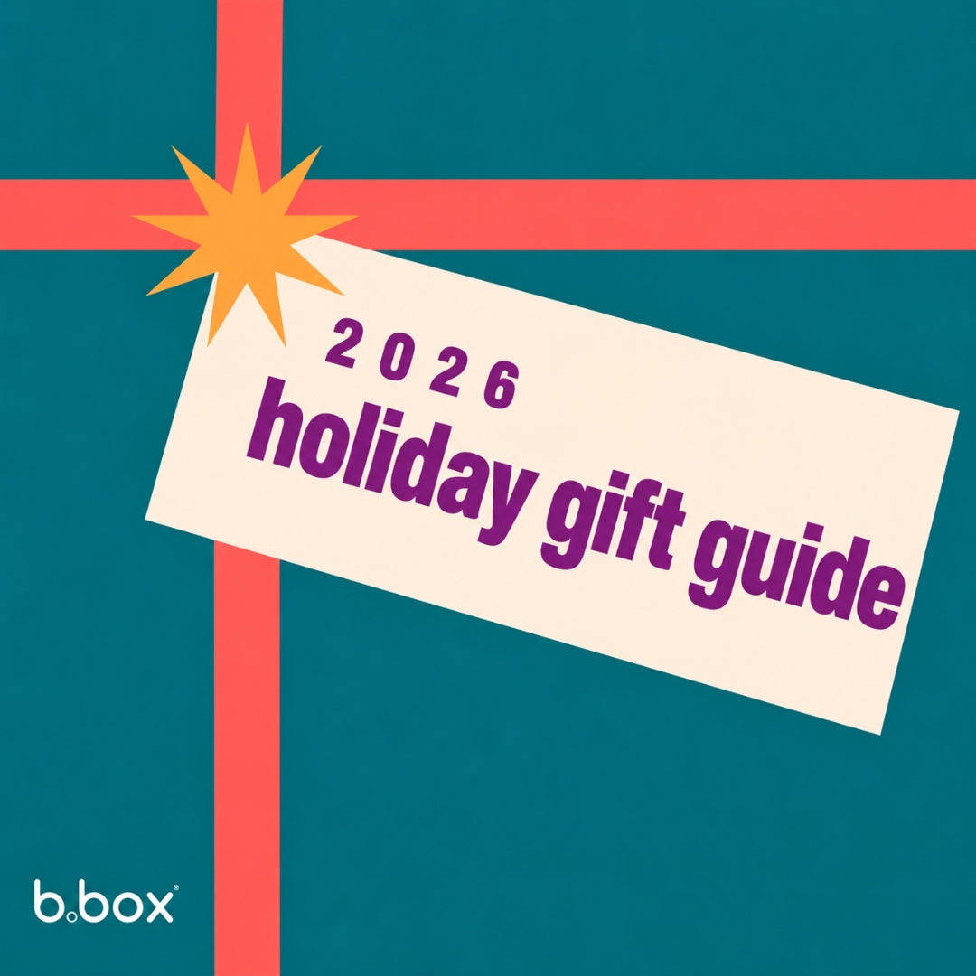 b.box 2026 holiday gift guide: a cream gift tag with purple text on a teal background, tied with a coral ribbon and an orange starburst.