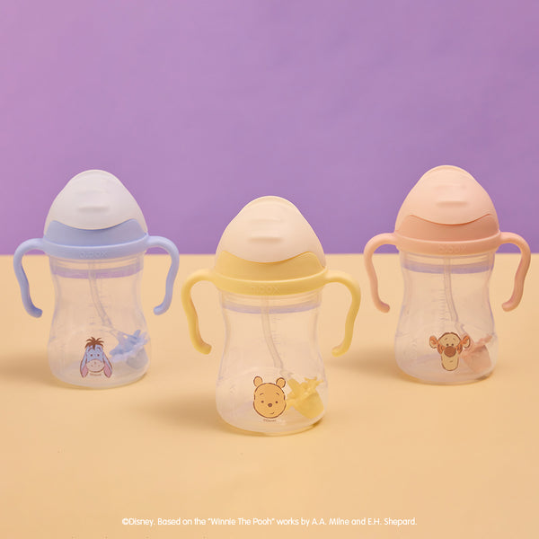 Three b.box winnie the Pooh sippy cups on a purple and beige background